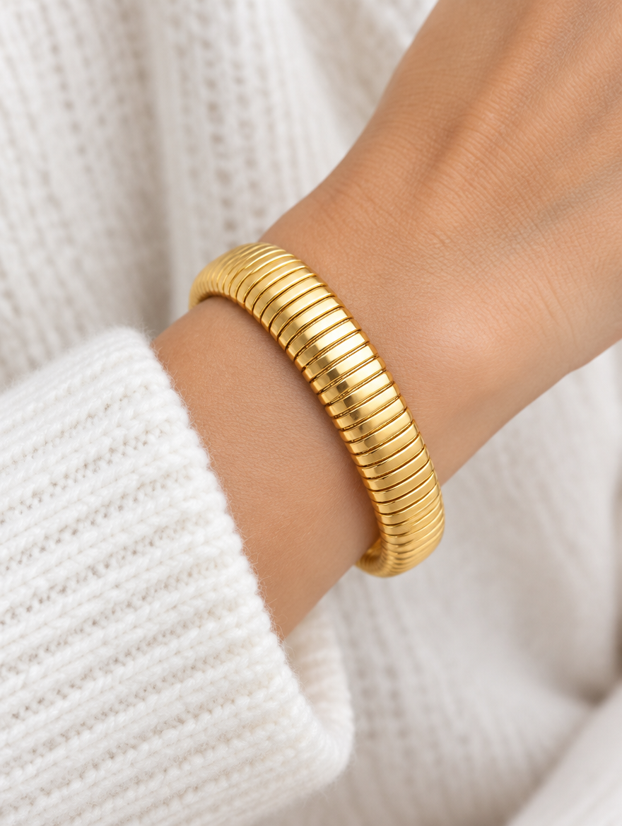 Woman wearing a gold wide ribbed stretch bracelet