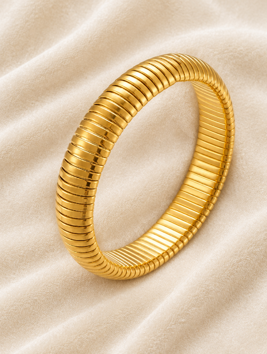 Gold ribbed stretch bracelet on cream velvet