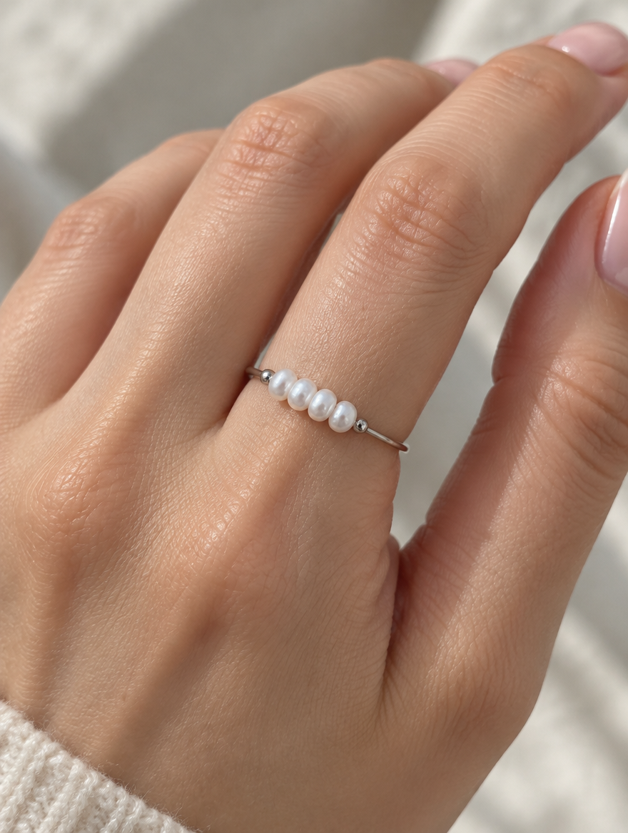 Woman wearing a silver four pearl band ring on her finger
