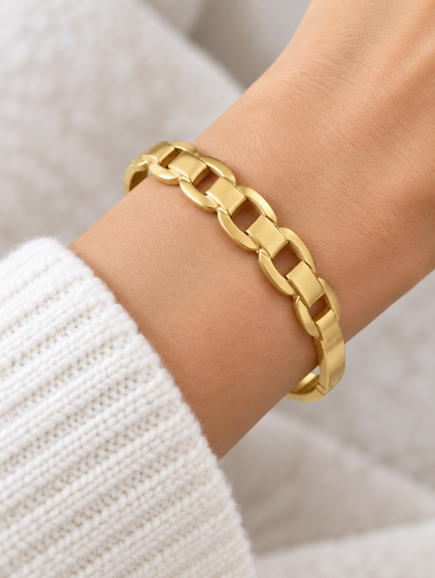 Woman wearing a gold hinged mariner link bangle