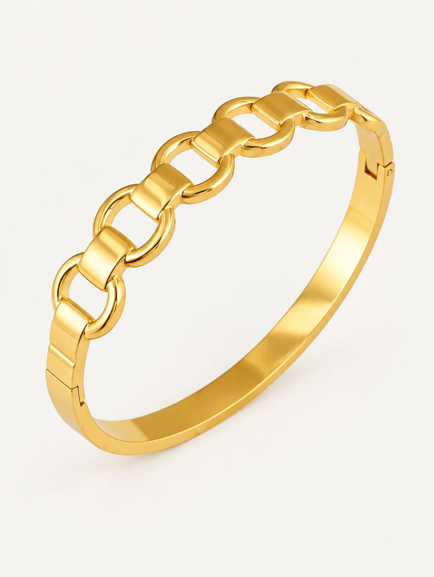 Gold hinged bangle with mariner link cut-outs on a neutral background