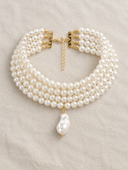Layered gold and pearl collar choker lying on soft linen