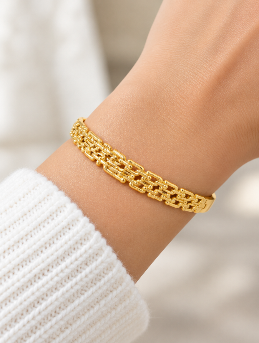 Woman wearing a gold hinged openwork bangle