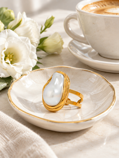 Gold oval baroque pearl ring in a small dish with styling props