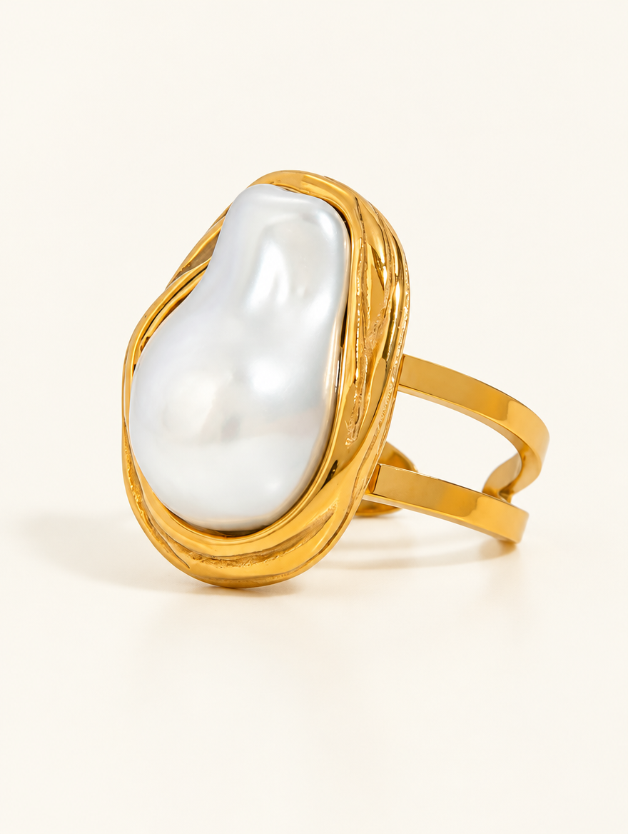 Gold oval baroque pearl ring on a neutral background