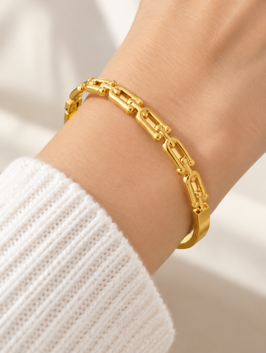 Woman wearing a gold hinged bangle with link cut-outs