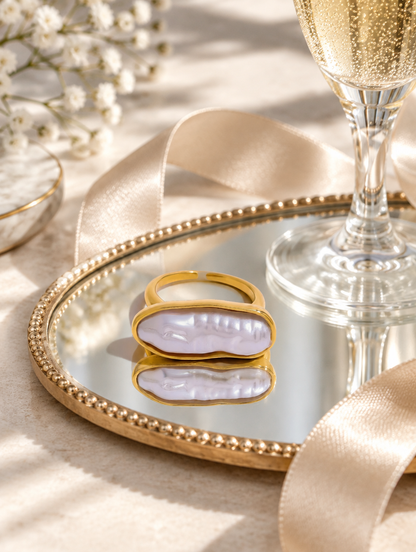 Gold long baroque pearl ring in a small dish with styling props
