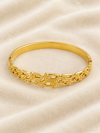 Gold openwork bangle on cream velvet