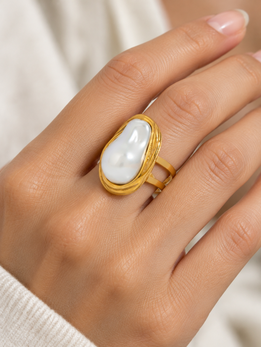 Woman wearing a gold oval baroque pearl ring on her finger