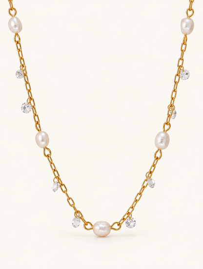 Gold-tone chain necklace with small pearls and clear zirconia accents on a neutral background
