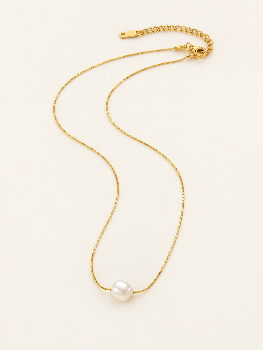 Gold-tone fine chain choker with a small freshwater pearl charm on a neutral background