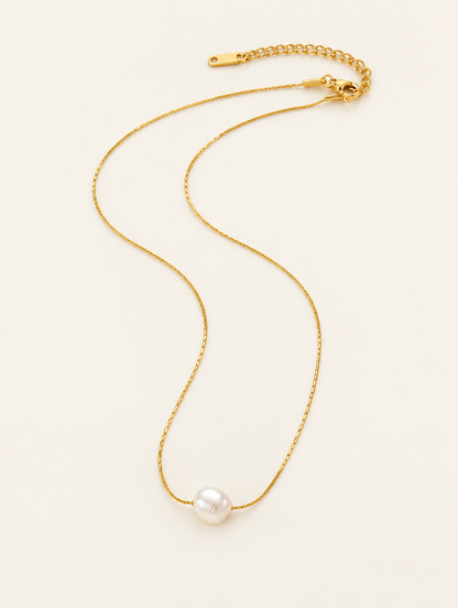 Gold-tone fine chain choker with a small freshwater pearl charm on a neutral background