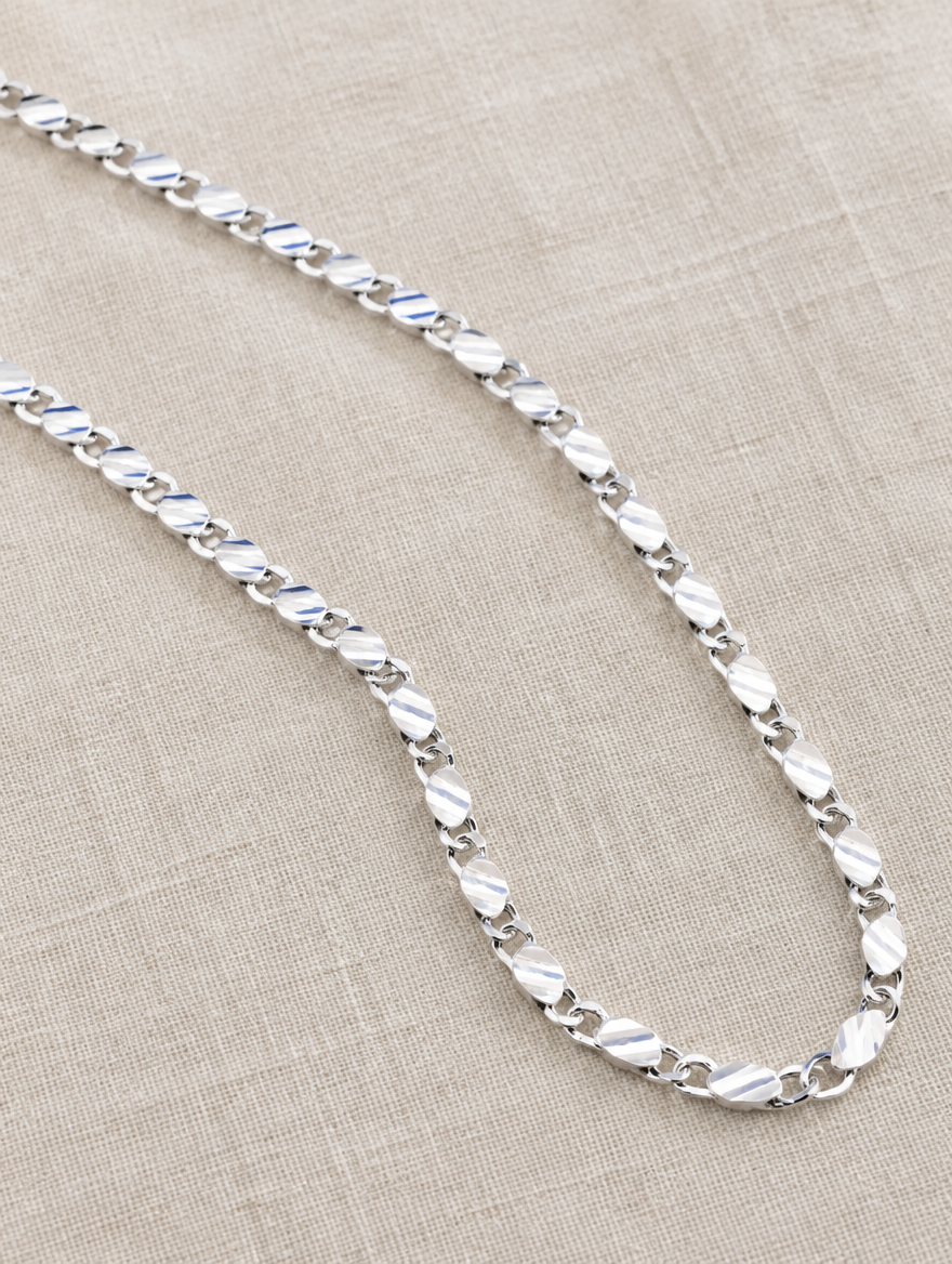 Silver side chain necklace lying on linen
