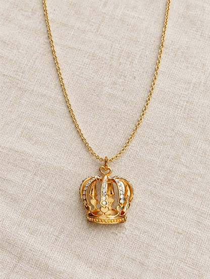 Gold crown necklace lying on linen