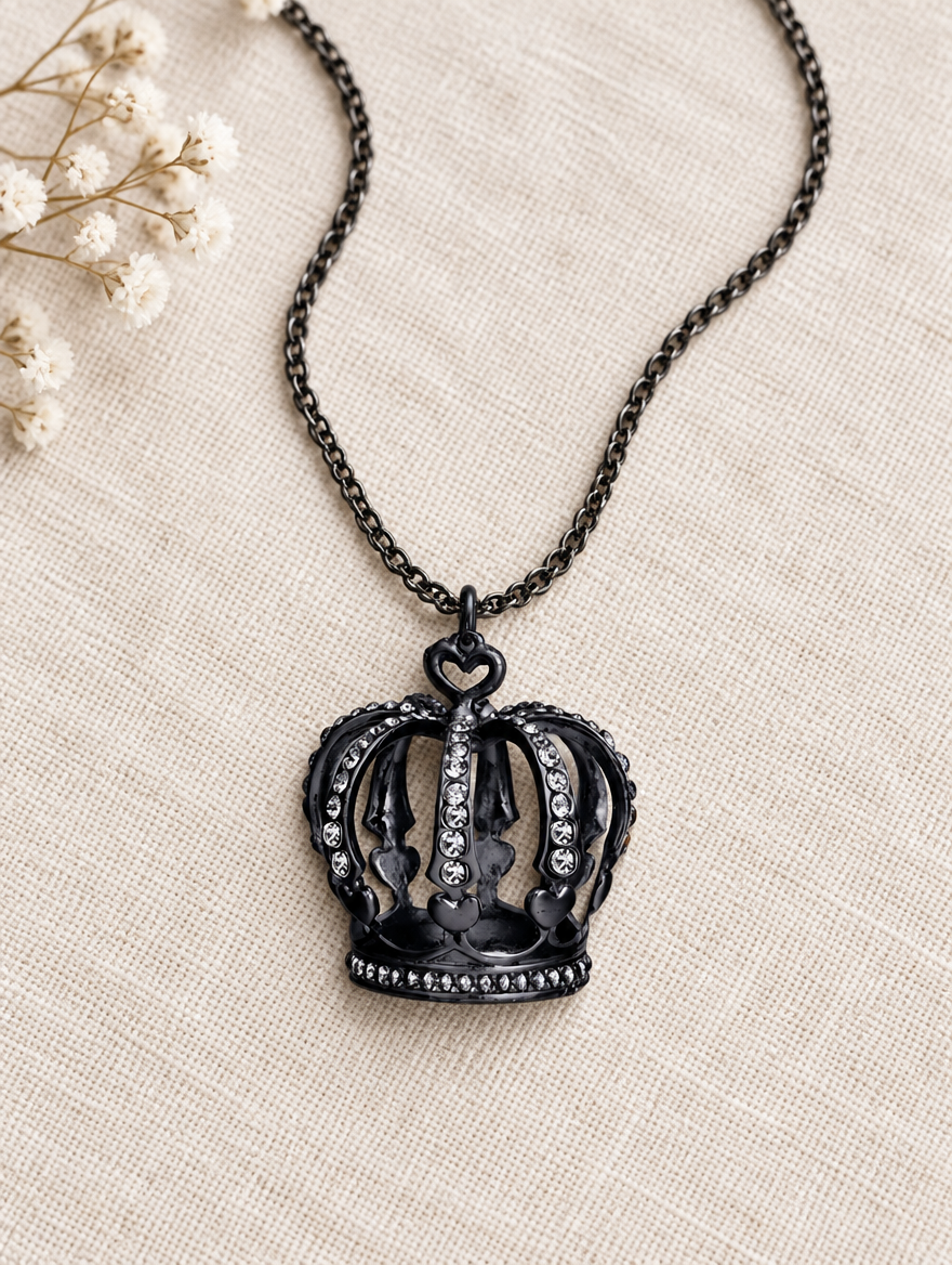 Black crown necklace lying on linen