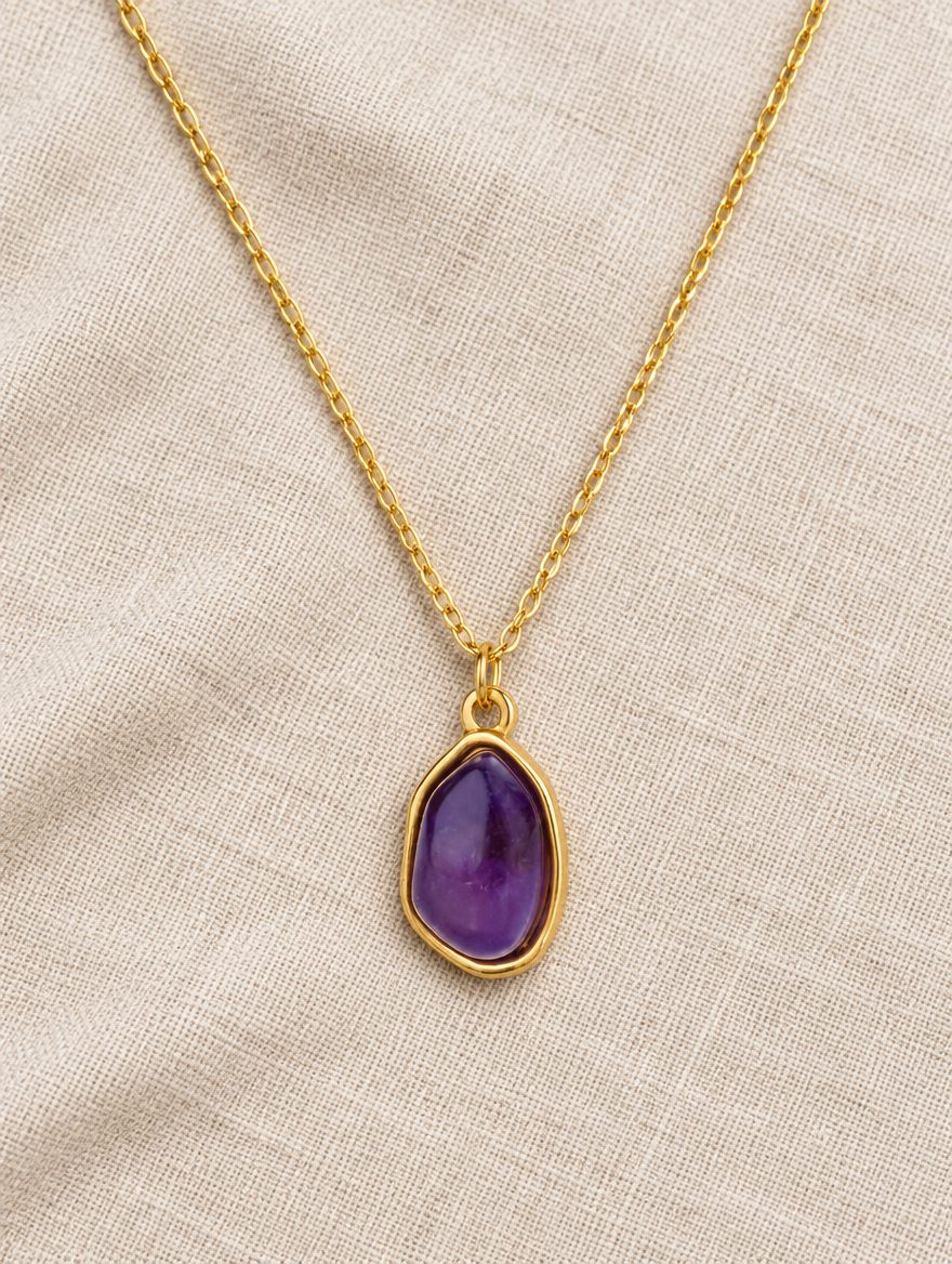 Purple stone pendant necklace lying on linen