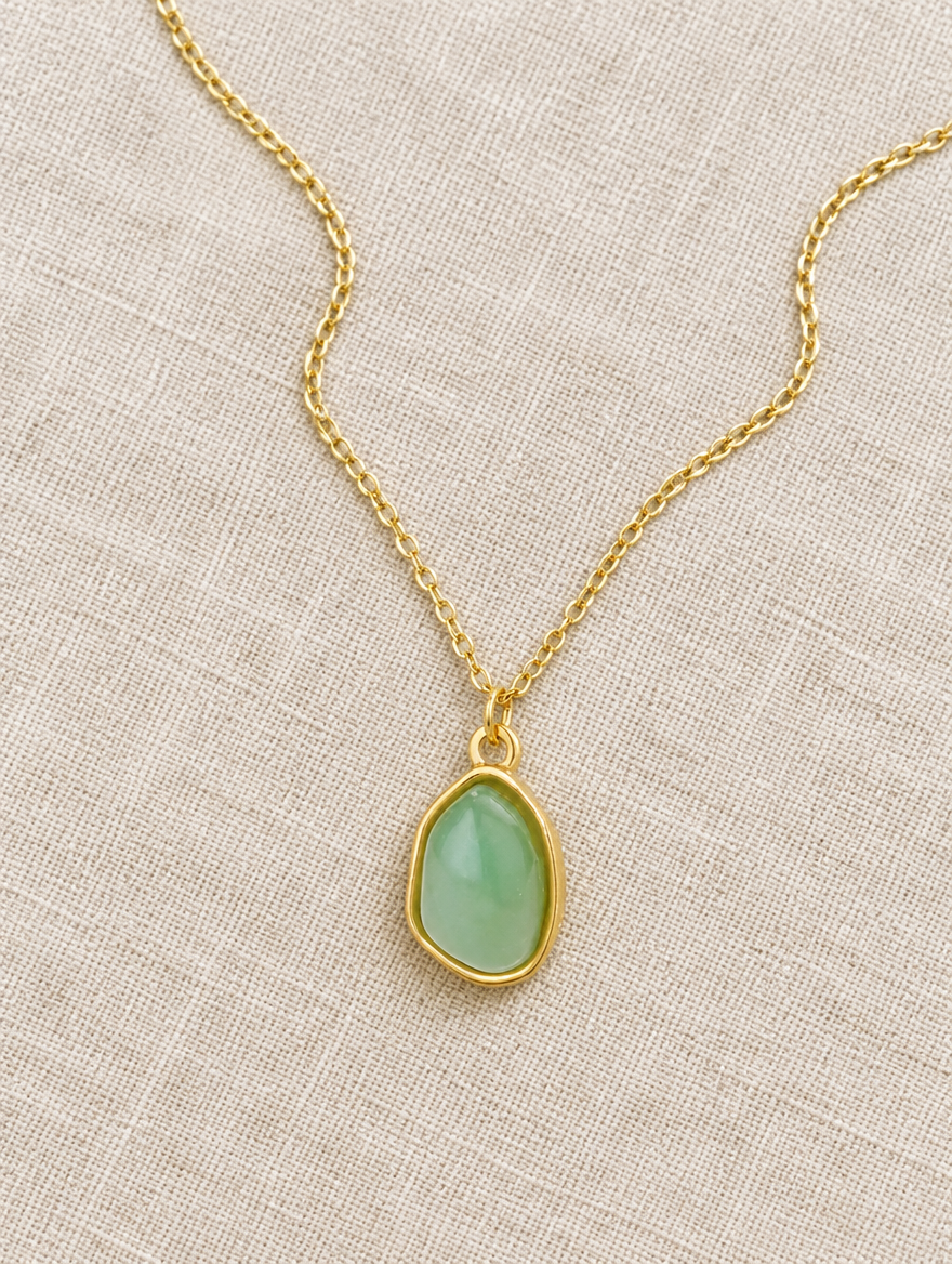 Green stone pendant necklace lying on linen