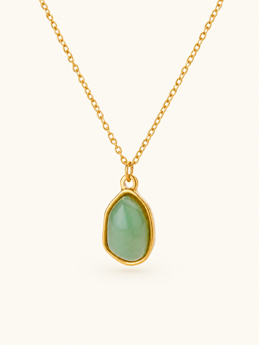 Gold-tone chain necklace with a green oval stone pendant on a neutral background