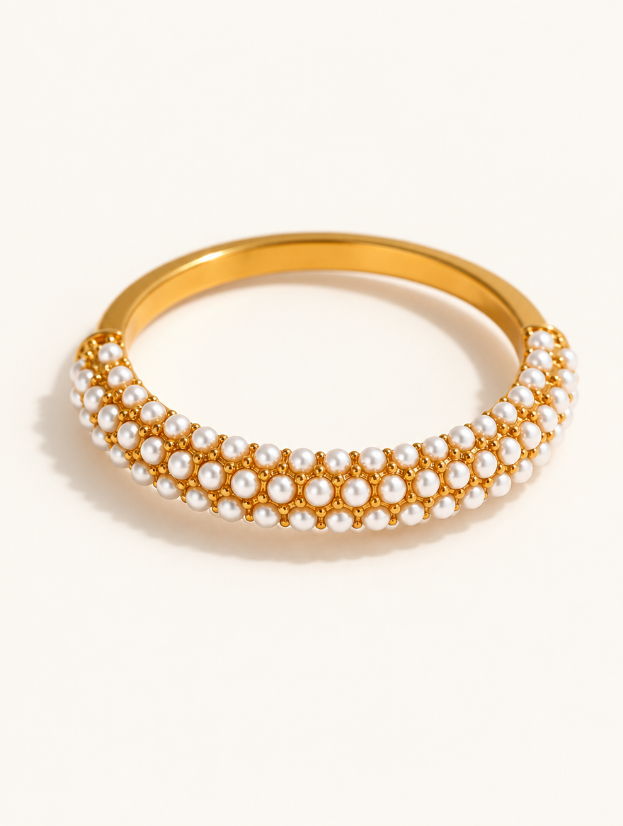 Gold pearl pavé band ring on a neutral background