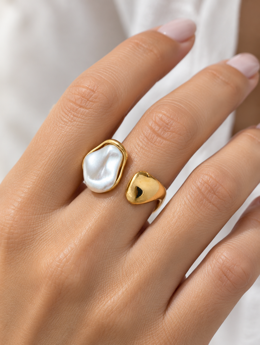 Woman wearing a gold baroque pearl teardrop ring on her finger