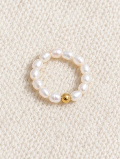 Freshwater pearl beaded stretch ring resting on a soft textured surface