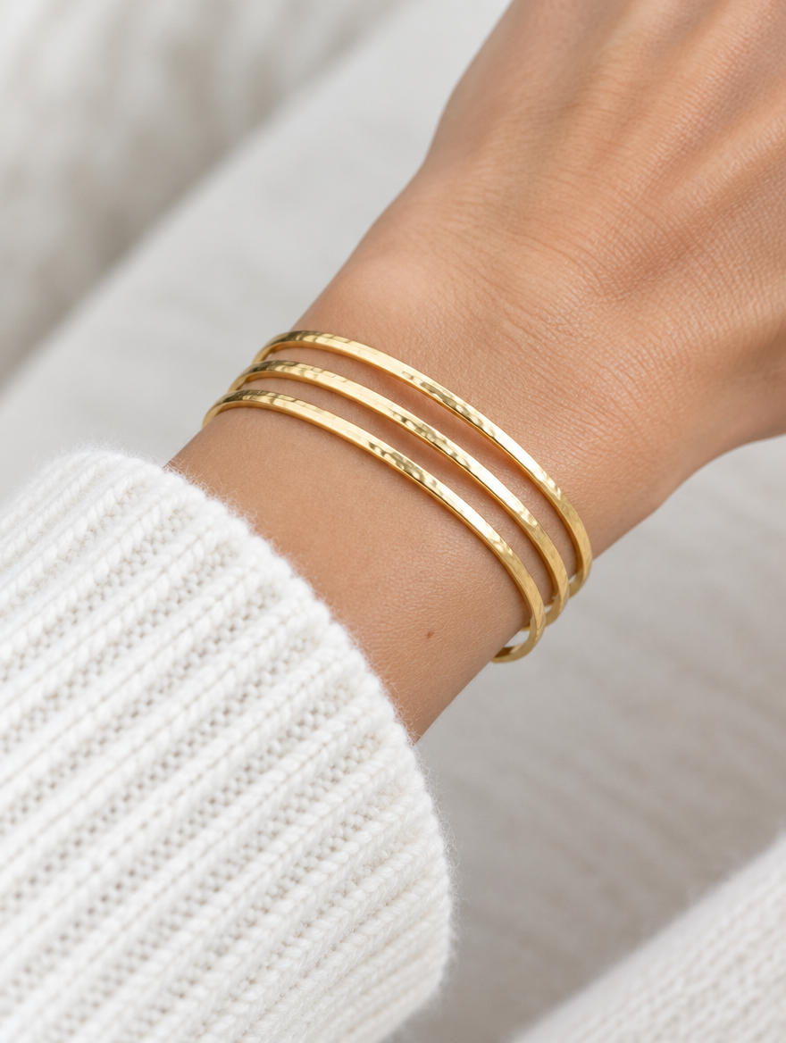 Woman wearing a gold triple line open cuff bracelet
