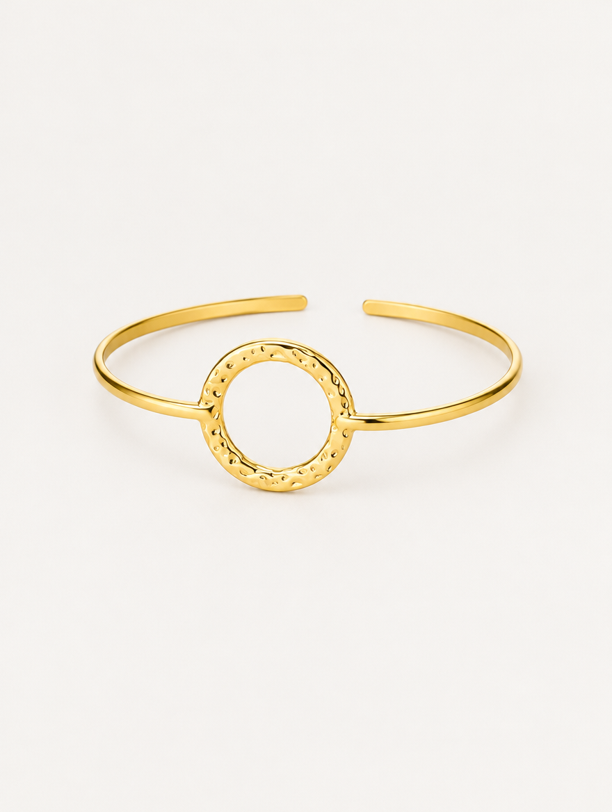 Gold circle open cuff bracelet on a neutral background