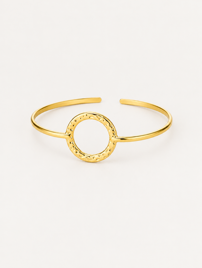 Gold circle open cuff bracelet on a neutral background