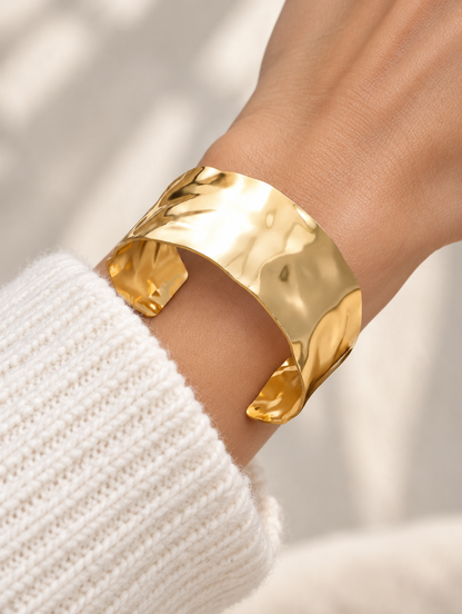 Woman wearing a wide hammered gold open cuff bracelet