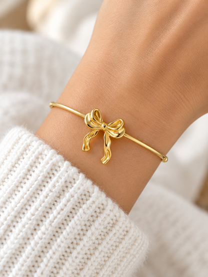 Woman wearing a gold bow open cuff bracelet