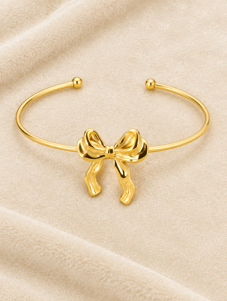 Gold bow cuff bracelet on cream velvet