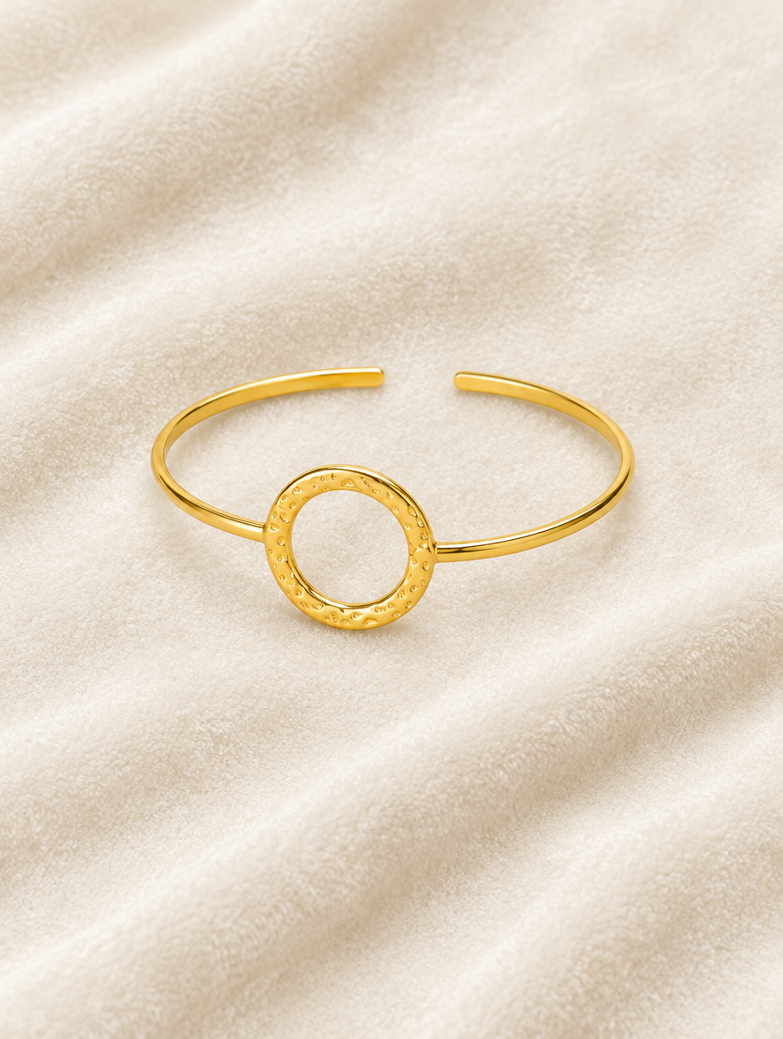 Gold circle cuff bracelet on cream velvet