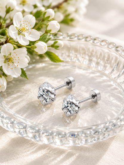 Silver claw-set cz stud earrings in a styled still life with props