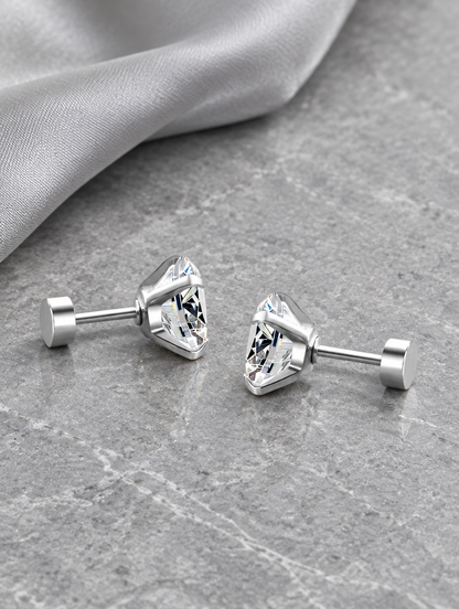 Silver claw-set cz stud earrings lying flat on a soft styled surface