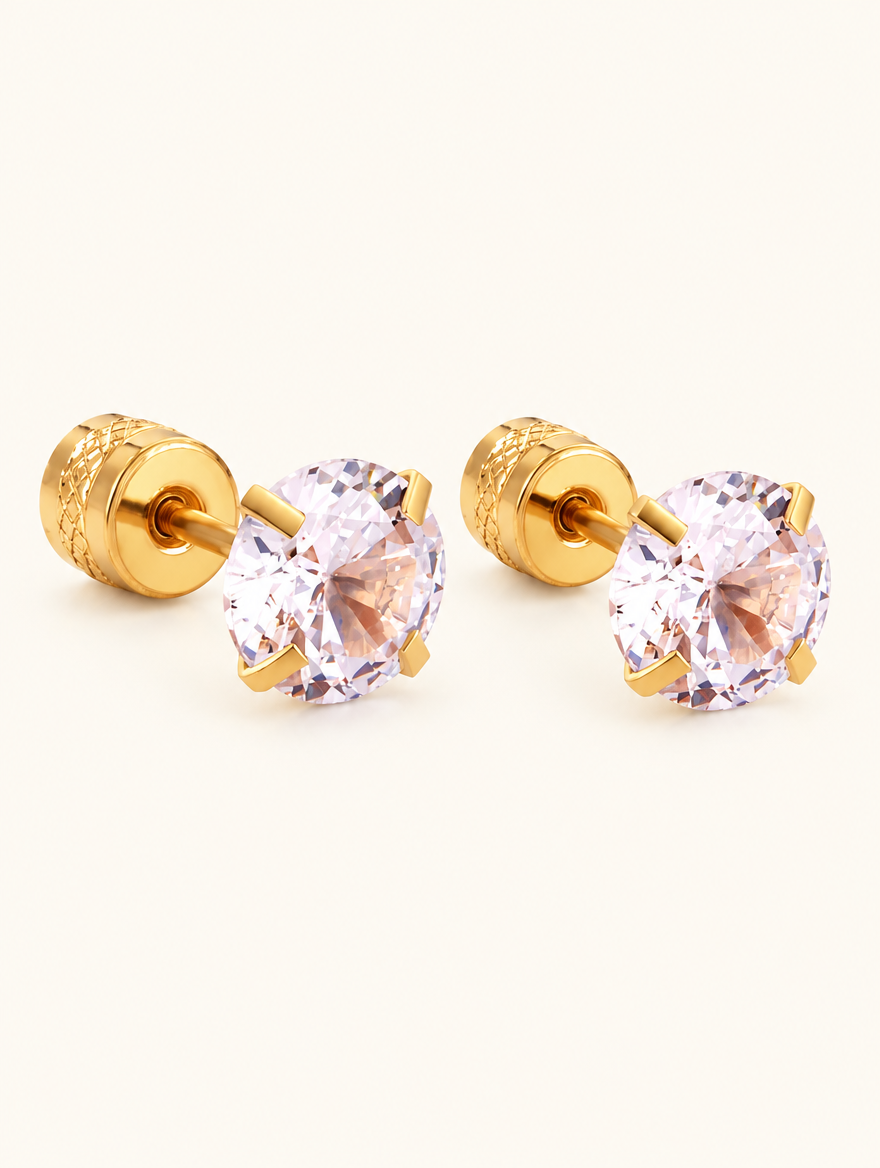 Pair of gold twist-back stud earrings with pink stone on a warm off-white background