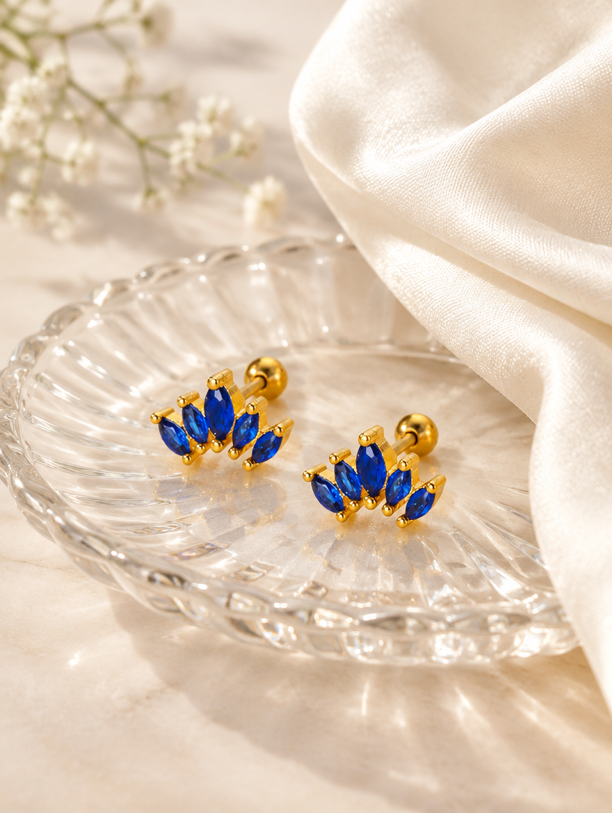 Gold blue marquise fan stud earrings in a styled still life with props