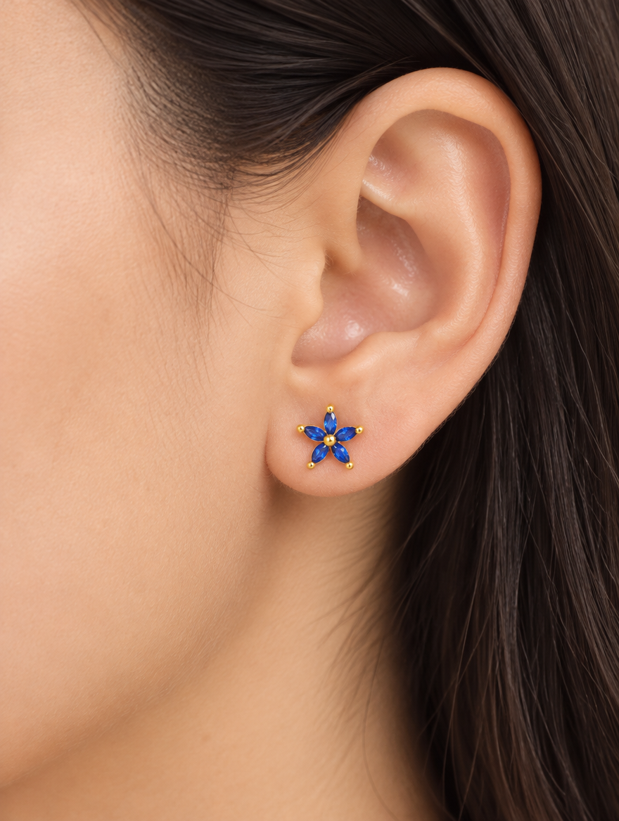 Woman wearing a gold blue flower stud earring