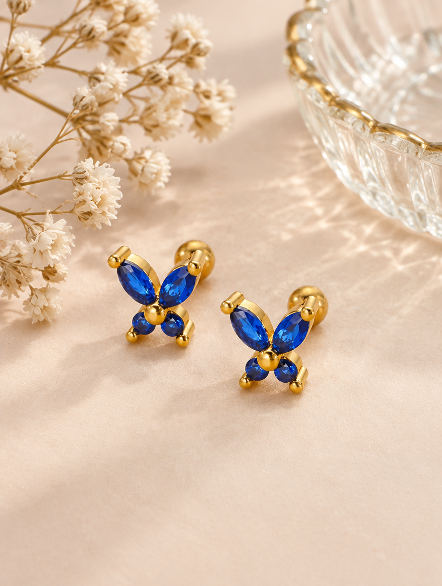 Gold blue butterfly stud earrings in a styled still life with props