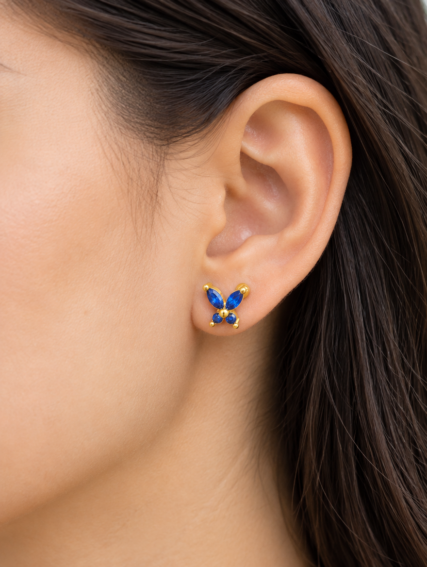 Woman wearing a gold blue butterfly stud earring