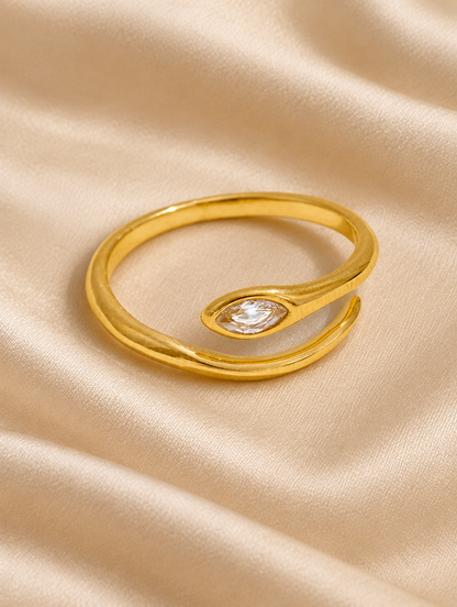 Gold snake head zirconia ring resting on a soft textured surface
