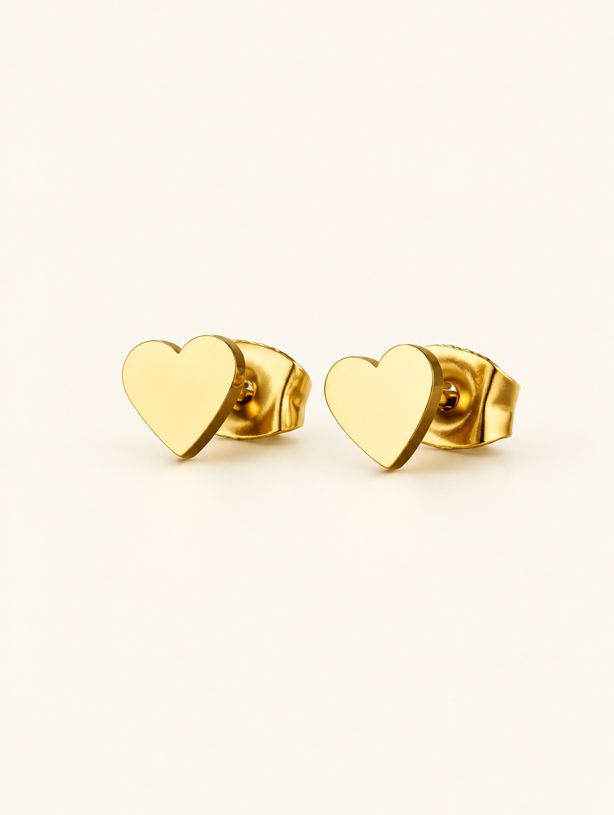 Pair of gold heart stud earrings on a warm off-white background