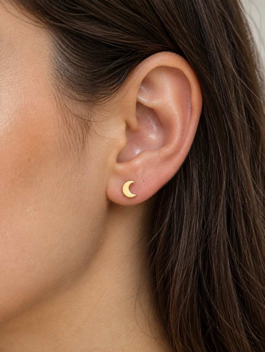 Woman wearing a gold crescent moon stud earring