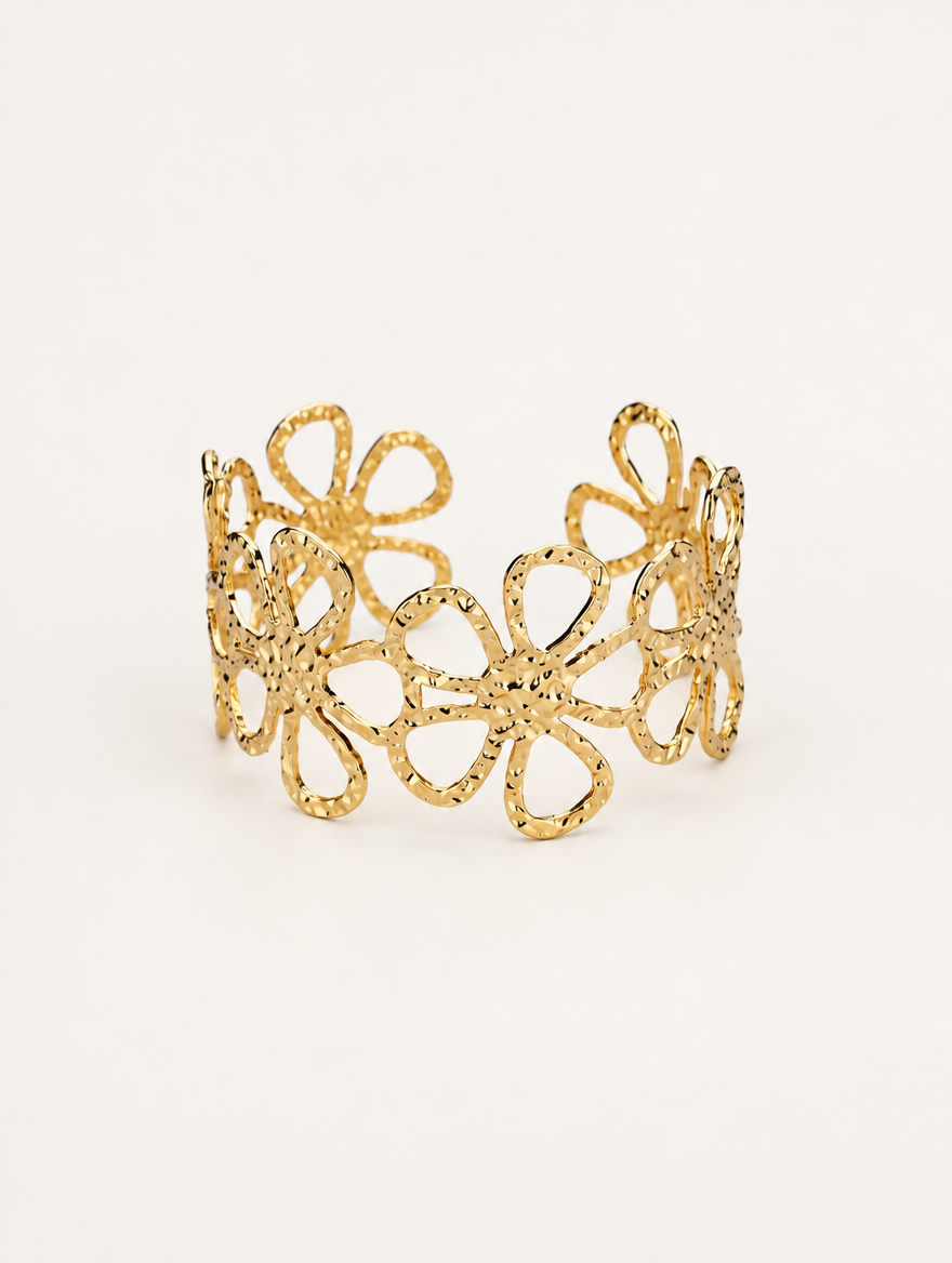 Gold outline flower openwork cuff bracelet on a neutral background