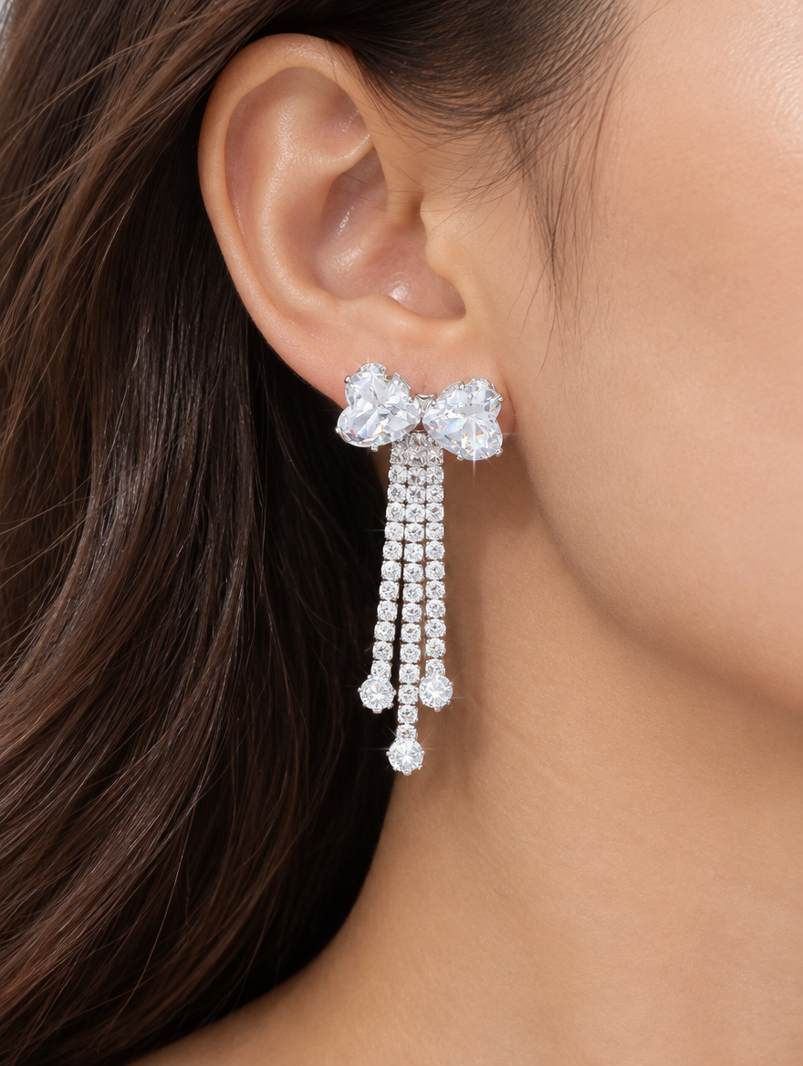 Woman wearing a silver crystal bow tassel drop earring