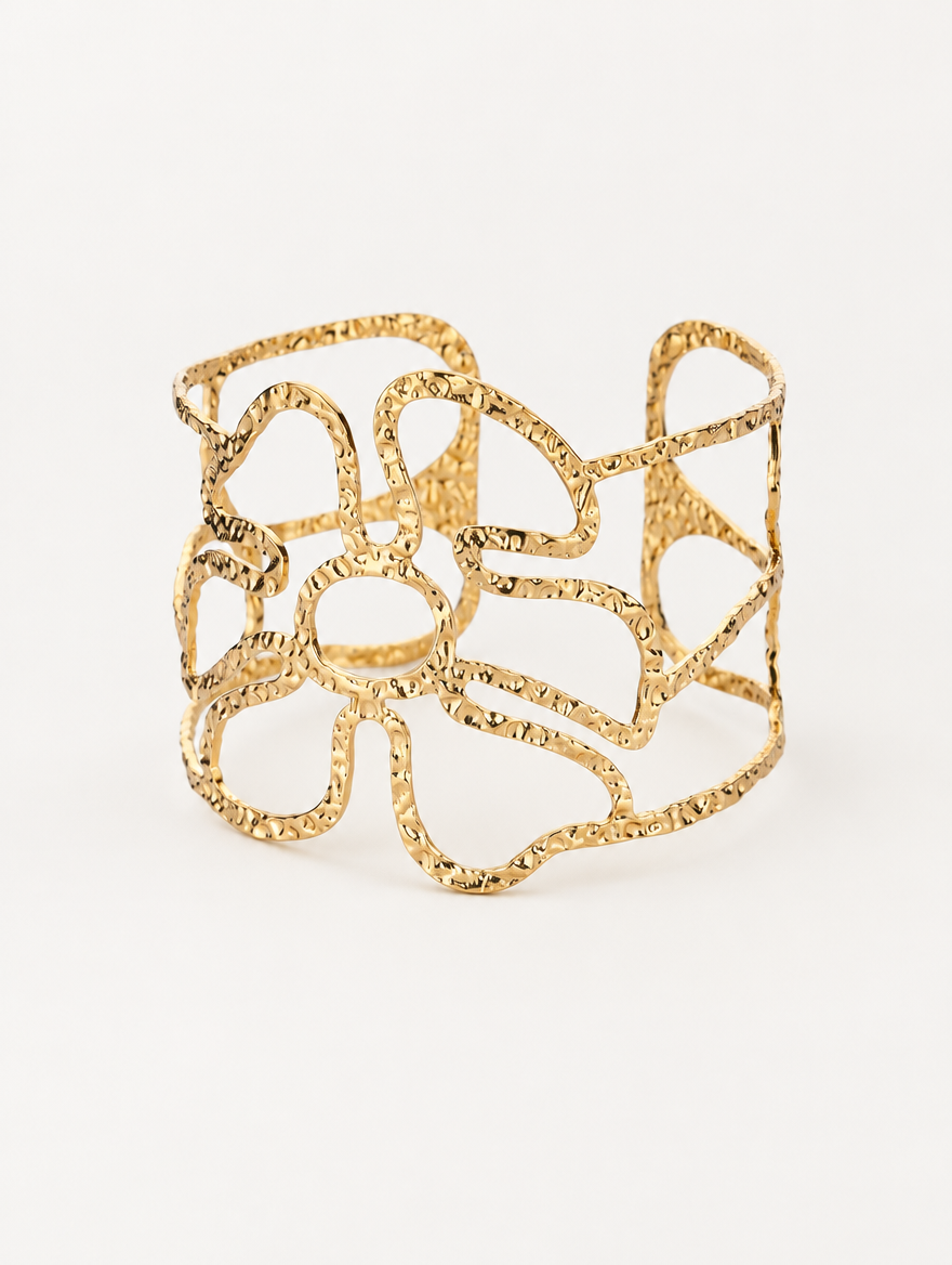 Gold wavy openwork cuff bracelet on a neutral background