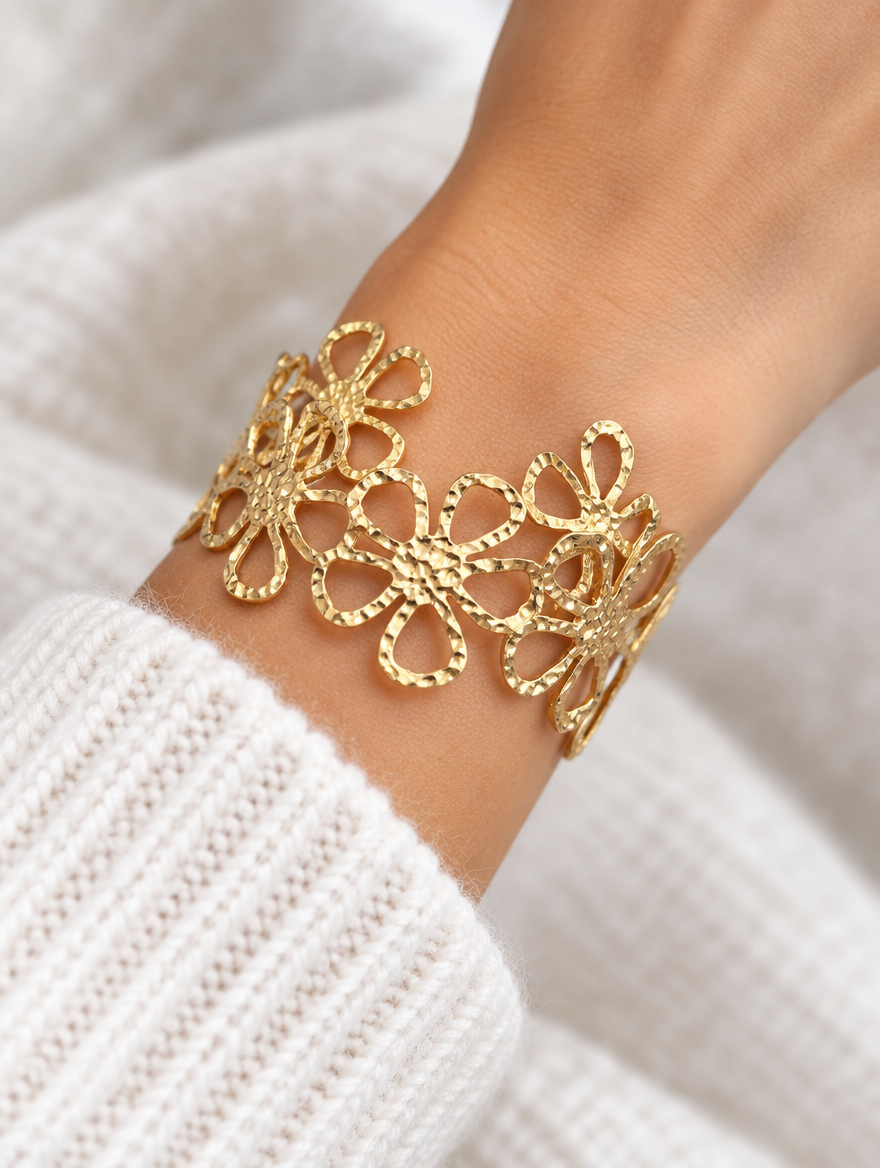 Woman wearing a gold outline flower openwork cuff bracelet
