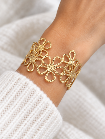 Woman wearing a gold outline flower openwork cuff bracelet