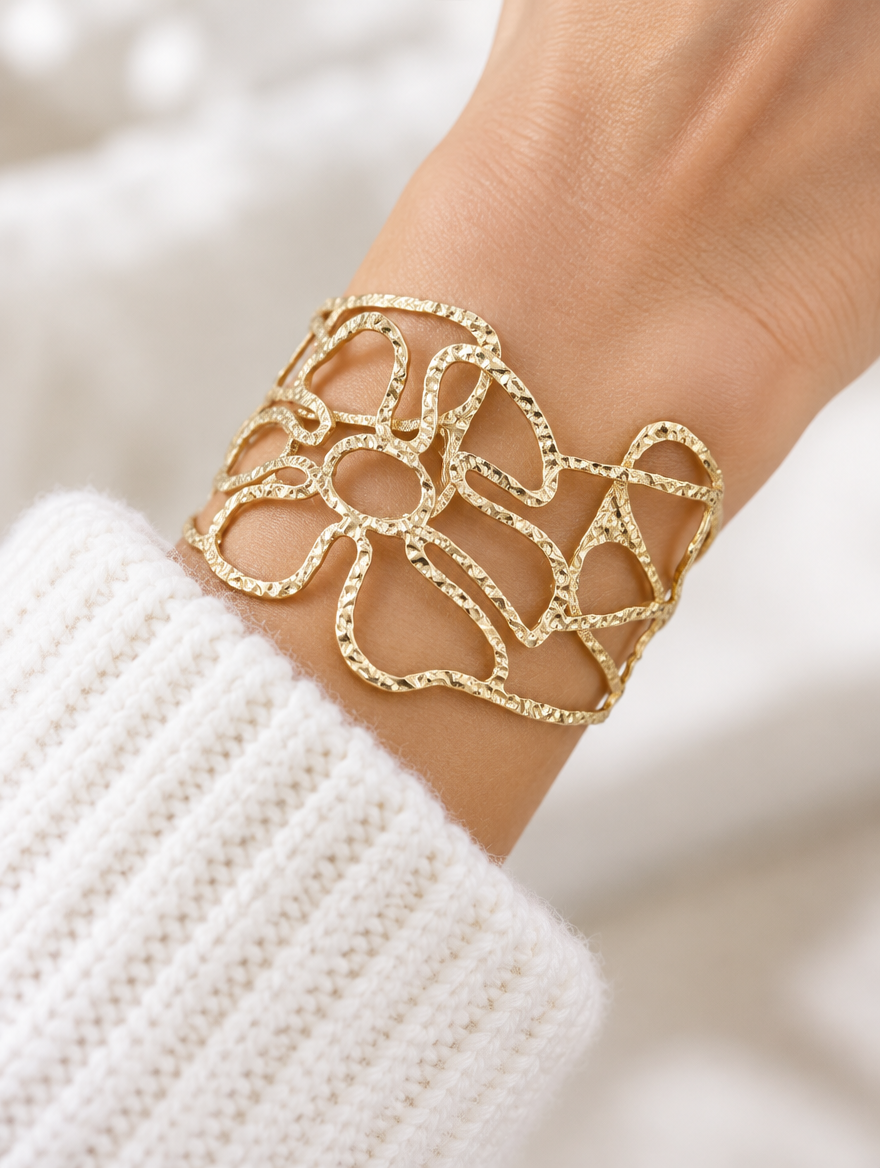 Woman wearing a gold wavy openwork cuff bracelet