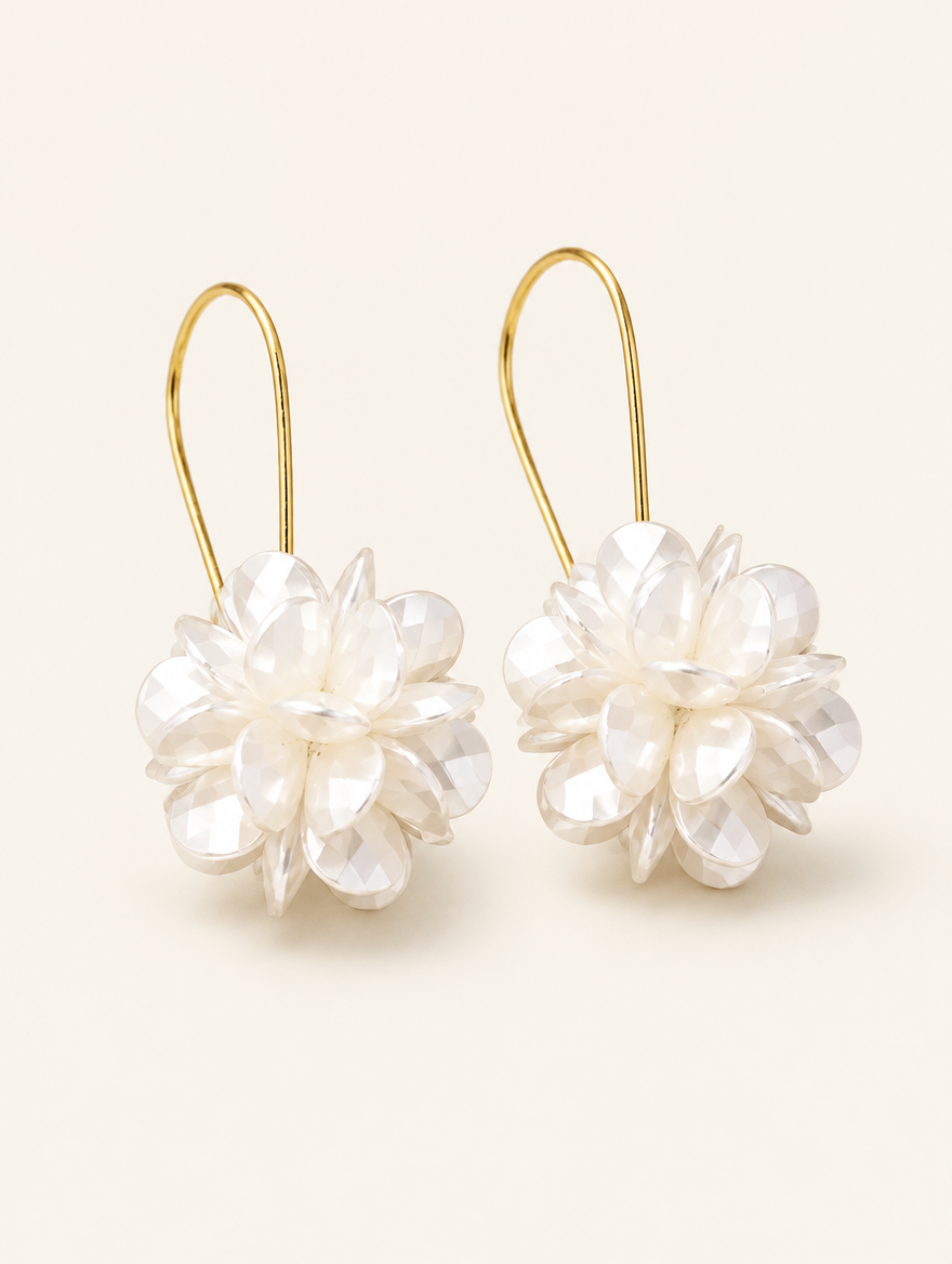 Pair of pearl-look petal ball hook earrings on a warm off-white background