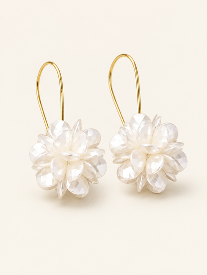 Pair of pearl-look petal ball hook earrings on a warm off-white background